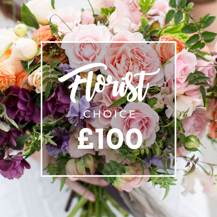 Framed by a neat white square overlay that reads Florist Choice in an elegant hand-lettered script, with the word CHOICE set in smaller capitals underneath and the clear, bold price ?100 below, this image presents a premium, florist-selected bouquet in all its tactile detail. Multiple large pink garden roses claim the foreground, each bloom plush and densely petalled with ruffled edges that catch the light and suggest a soft, velvety touch. Woven between them are pale purple-and-white sweet peas, their almost-striped petals and slender stems adding a sense of movement and vintage charm. Deeper plum or burgundy hellebores gather in shaded clusters, providing a dramatic counterpoint that gives the arrangement depth and a moody refinement. Warm peach and coral ranunculus-like blooms glow amid creamy white accent flowers that act as small bright notes across the bouquet. The greenery is abundant and varied - from trailing vines and delicate sprays to broader, matte leaves - creating a natural, garden-style silhouette and a fresh textural backdrop. At the bottom, a pair of hands gently holds the gathered stems; a faint pale sleeve and the blurred suggestion of clothing behind them make the bouquet feel hand-delivered and personal. As a local florist in Brent, I imagine this arrangement arriving for a birthday in Kilburn, a wedding rehearsal near Wembley Park, or a quiet thank-you left with neighbours on a tree-lined street. Flower Delivery Brent prepares bouquets like this for same-day delivery across the borough, offering seasonal, handcrafted selections that celebrate both occasion and community.